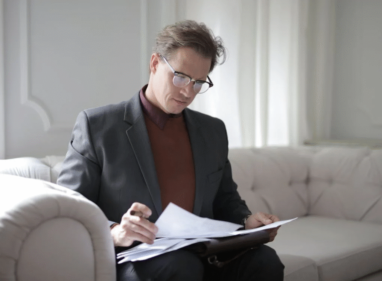 a man in a blazer holding a document.