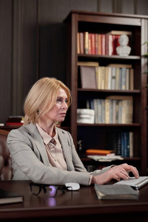 a woman with blonde hair typing on a keyboard.