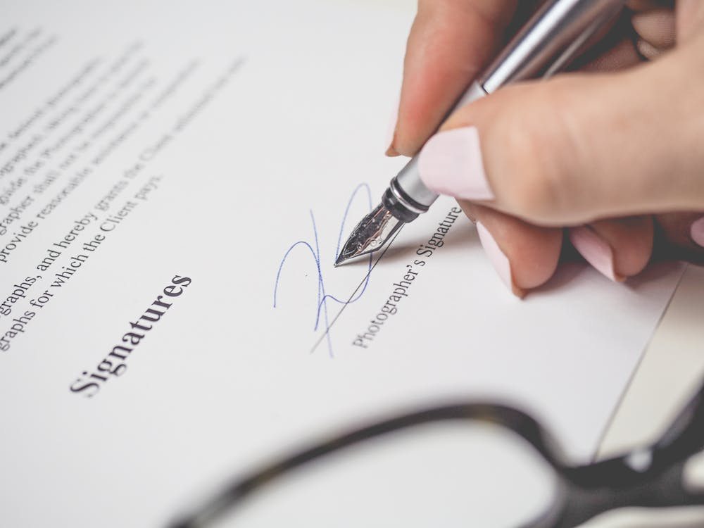 Close-up of pen signing a legal agreement document